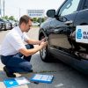 Un expert automobile prend en photo les dégâts sur une voiture à l’extérieur.
