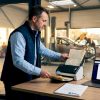 Le chef d’atelier procède à la numérisation des dossiers clients depuis son bureau aménagé dans l’atelier.