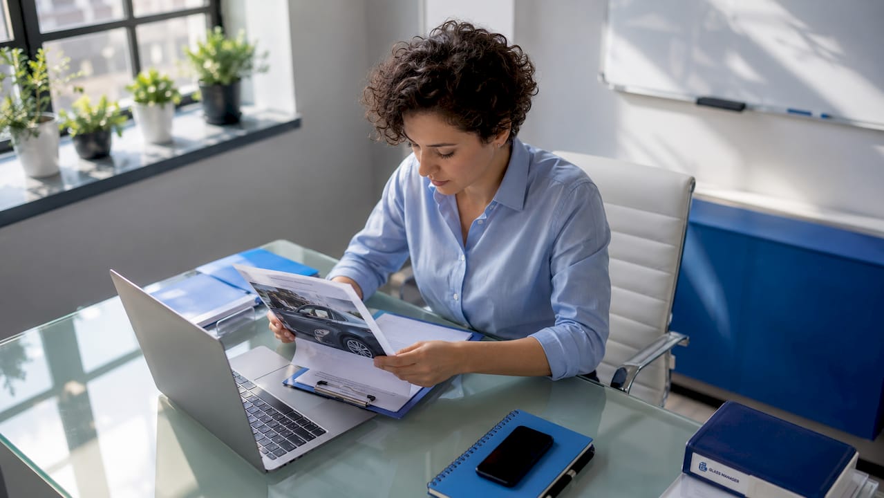 Un expert analyse un rapport de dommages sur des vitrages à son bureau.