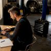 Un technicien automobile en atelier effectuant des diagnostics à l’aide d’un ordinateur