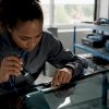 Un technicien vérifie si le pare-brise du véhicule est bien adapté et conforme aux spécifications.