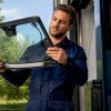 Un technicien procède au réglage des capteurs ADAS installés sur le pare-brise d’un véhicule.