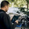 Mains d'un technicien posant une tablette sur l'établi de l'atelier
