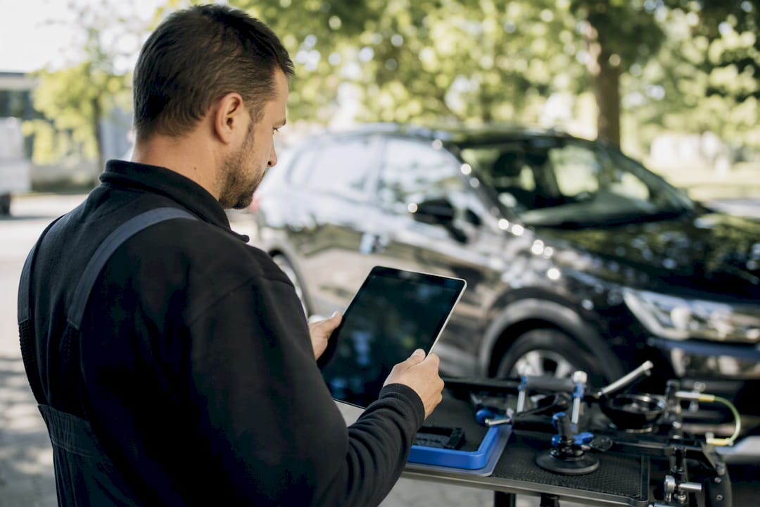 Mains d'un technicien posant une tablette sur l'établi de l'atelier