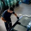 Mains d'un technicien installant un pare-brise dans un atelier