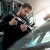 Mains préparant un injecteur de résine pour la réparation de pare-brise