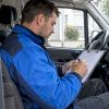 Technicien vitrage remplissant une facture mobile