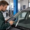 Technicien en train de contrôler un pare-brise équipé de l’ADAS