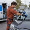Un technicien en train de remplacer un pare-brise à côté de son camion